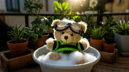 There is a wash basin on the balcony, and in the basin is a brown mini teddy bear wearing green and black stripes being cleaned.